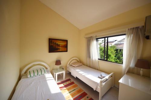 twee bedden in een kamer met een raam bij Christos beach house in Larnaka