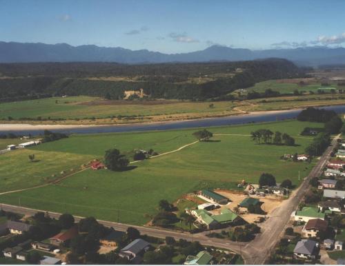 an aerial view of a town with a river and houses at Karamea Hotel in Karamea