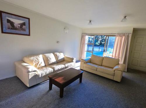 a living room with two couches and a coffee table at Ruapehu Mountain Motel & Lodge in Ohakune