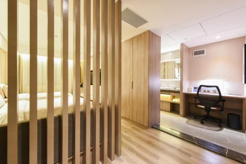 a bedroom with a bed and a desk and a chair at Atour Hotel Langfang Xichang Road in Langfang