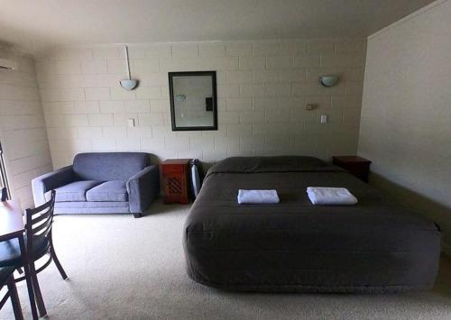 a bedroom with a large bed and a couch at Ruapehu Mountain Motel & Lodge in Ohakune