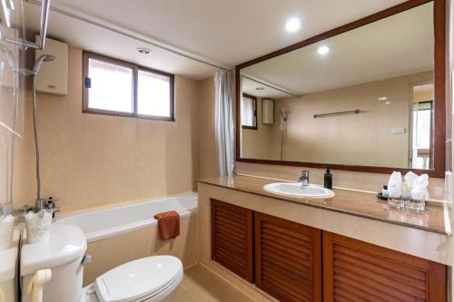 a bathroom with a sink and a toilet and a mirror at Bangkok ShortStay, 2-3BR SUKHUMVIT in Bangkok