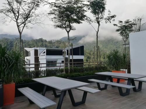 two picnic tables on a patio with a view of a mountain at BigWonder at Midhills Genting 2R2B in Genting Highlands