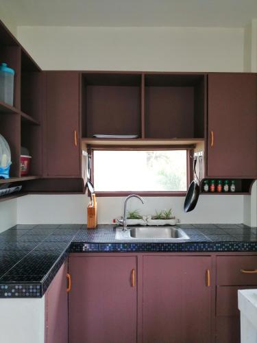 a kitchen with a sink and a window at Happy's Homestay in Boracay