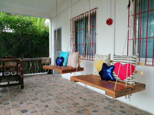 a porch with two benches with pillows on it at Happy's Homestay in Boracay