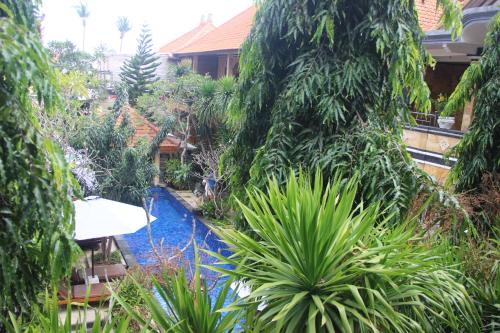 a garden with a swimming pool in front of a house at Nitya Home Stay Lembongan in Nusa Lembongan