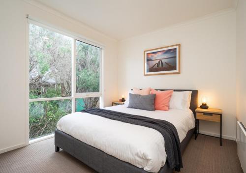 a bedroom with a bed and a large window at Capri House in Saint Andrews Beach