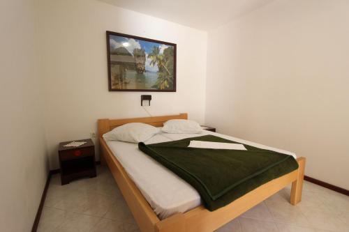 Un dormitorio con una cama con una manta verde. en Room and Apartments Mariza, en Rovinj