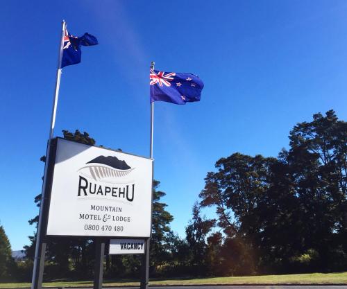 two blue flags flying above a sign with a sign at Ruapehu Mountain Motel & Lodge in Ohakune