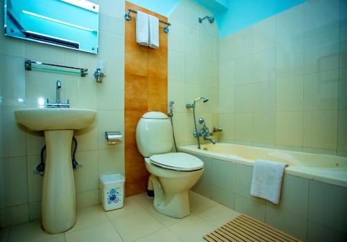 a bathroom with a toilet and a sink and a tub at Hotel Tara in Pokhara