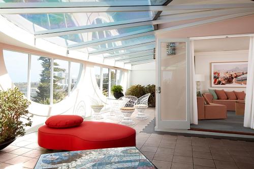 a living room with a red ottoman in a room at Hotel Ravesis in Sydney