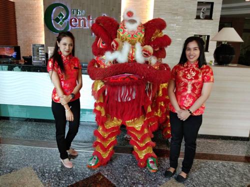 two women standing next to a giant chinese dragon costume at The Centris Hotel Phatthalung in Phatthalung