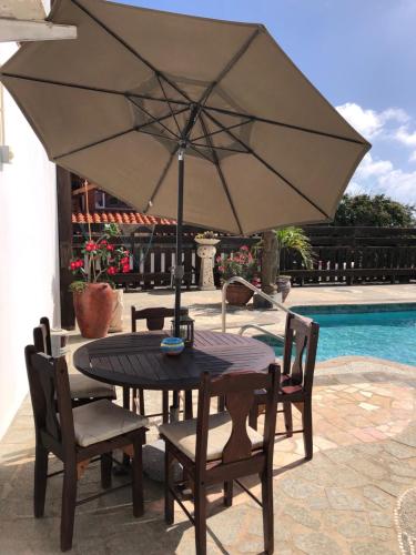 a table and chairs with an umbrella next to a pool at Via Monica in Santa Cruz