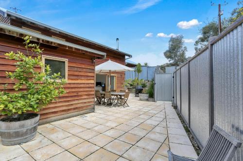 
a patio area with a wooden fence and a brick building at Seascape Retreat in Victor Harbor
