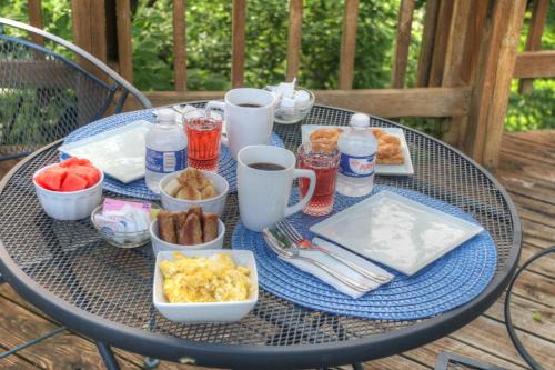 Una mesa con alimentos y bebidas para el desayuno. en Hidden Springs Bed and Breakfast, en Eureka Springs