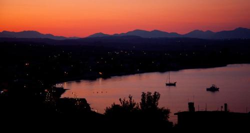 a sunset over a river with a boat in it at Erato Apartments in Petalidhion