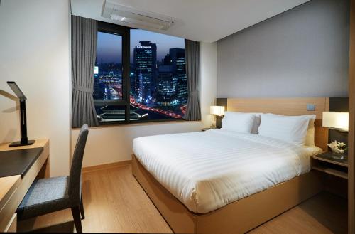 a bedroom with a bed and a desk and a window at Fraser Place Namdaemun Seoul in Seoul