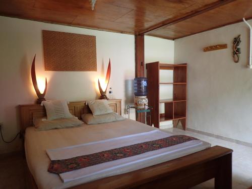 Un pat sau paturi într-o cameră la Two Fish Resort Lembeh