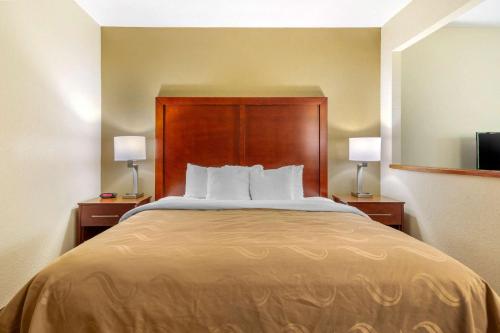 a large bed in a hotel room with two lamps at Quality Inn & Suites Olde Town in Portsmouth