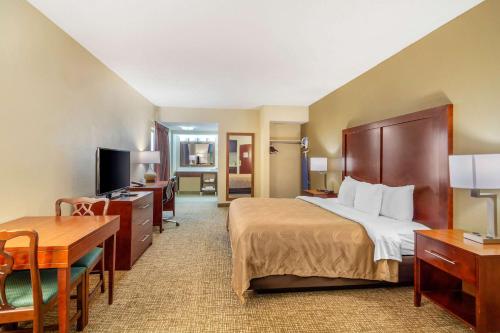 a hotel room with a bed and a desk at Quality Inn & Suites Olde Town in Portsmouth