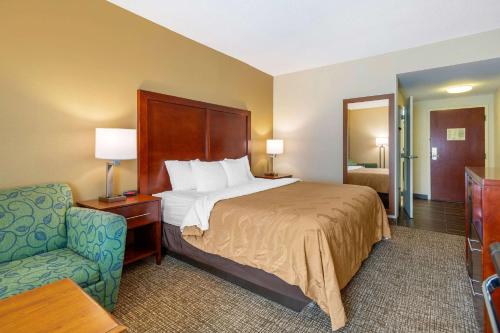 a hotel room with a bed and a chair at Quality Inn & Suites Olde Town in Portsmouth