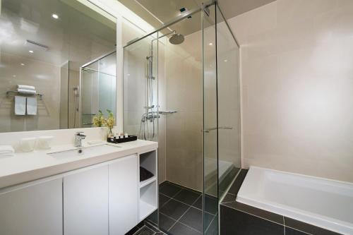 a bathroom with a shower and a sink and a tub at Fraser Place Namdaemun in Seoul