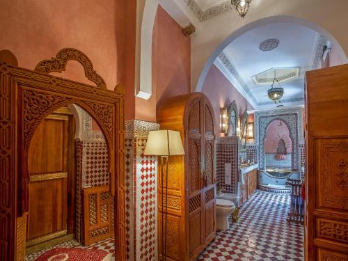 ein Bad mit einem Torbogen und einem WC in einem Zimmer in der Unterkunft Riad & Spa Laurence Olivier in Marrakesch