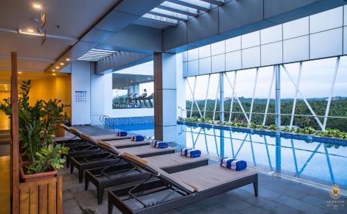 a row of chaise lounges in a hotel pool at KPM TRIPENTA HOTEL in Kozhikode