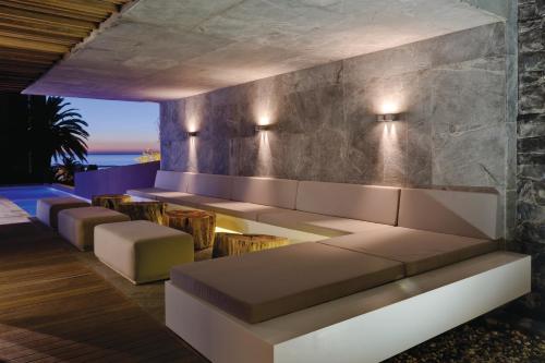 a living room with a couch and chairs and the ocean at POD Camps Bay by The Oyster Collection in Cape Town