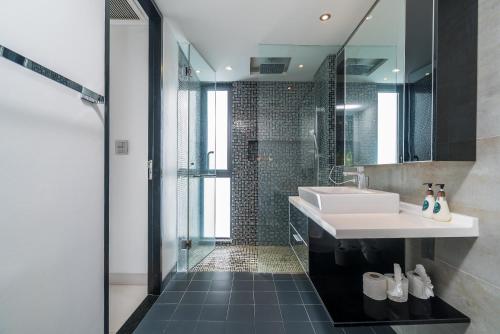 a bathroom with a white sink and a shower at Absolute Twin Sands by Lofty in Patong Beach