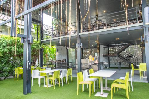 a restaurant with yellow chairs and tables in a building at Lantana Pattaya - SHA Extra Plus in Pattaya North