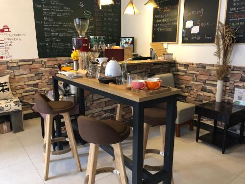 blat z stołkami i stół w restauracji w obiekcie Zhangjiajie Cloud Youth Hostel w mieście Zhangjiajie