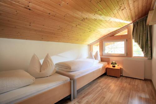 ヴェステンドルフにあるAppartement Martinaの木製天井の小さな部屋のベッド2台