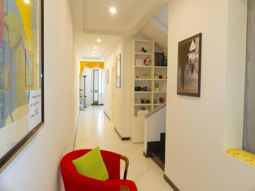 a living room with a red chair and a hallway at Il Fiore di Monnalisa in Vinci