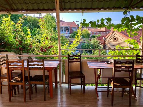 a wooden table and chairs on a porch with a view at Nato & Lado in Sighnaghi