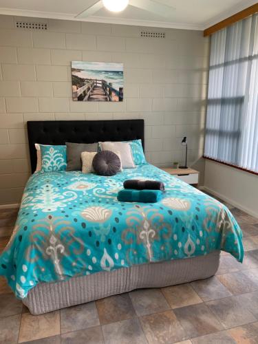 een slaapkamer met een groot bed en een blauw dekbed bij Longbeach Apartments in Coffin Bay