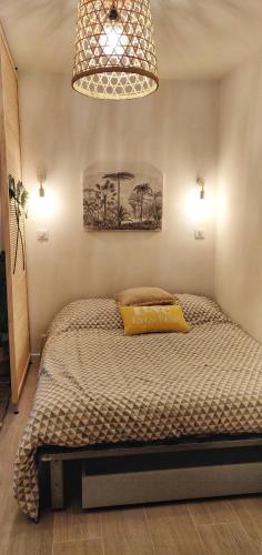 - une chambre avec un lit et un oreiller jaune dans l'établissement Plage à 3 minutes à pied, à Saint-Raphaël