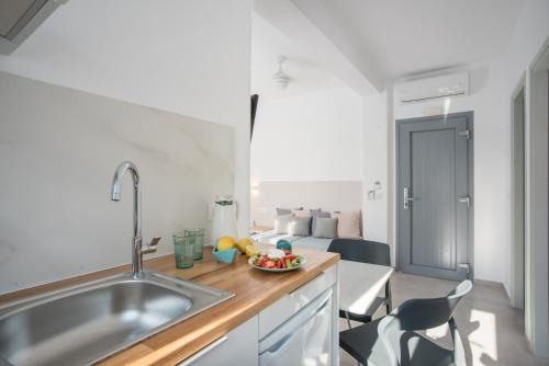 a kitchen with a sink and a table with a bowl of fruit at Nautilus Apartments-Suites in Parikia