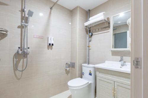 ein Bad mit einer Dusche, einem WC und einem Waschbecken in der Unterkunft Floral Hotel · Yu Wan Holiday Lingshui in Lingshui