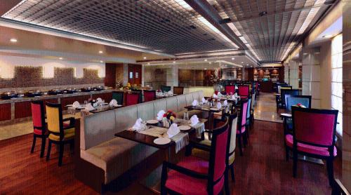 a restaurant with tables and chairs and a bar at Lords Plaza Jaipur in Jaipur