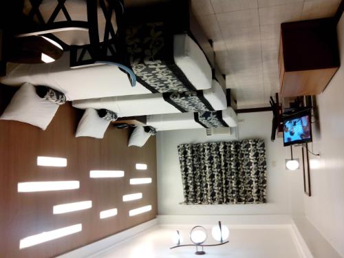 ein Badezimmer mit Toilettenpapierrollen und einem Fernseher in der Unterkunft Jupiter Suites in Manila