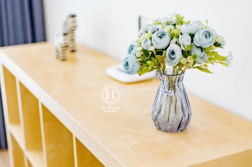 a vase of flowers sitting on top of a table at Hi-Home Suites - Vinhomes Metropolis in Hanoi