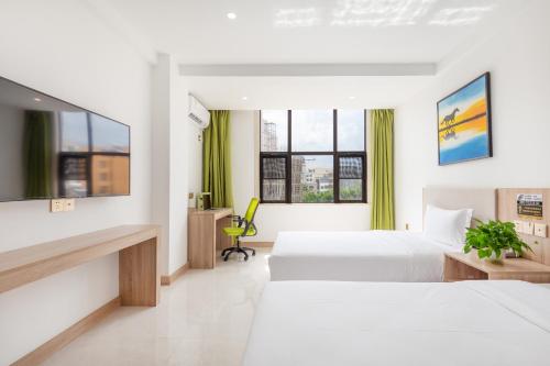 a hotel room with two beds and a desk at Floral Hotel · Yu Wan Holiday Lingshui in Lingshui