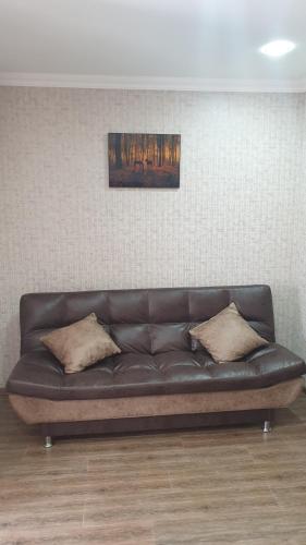 a black leather couch sitting in a room at Comfort in Tbilisi City