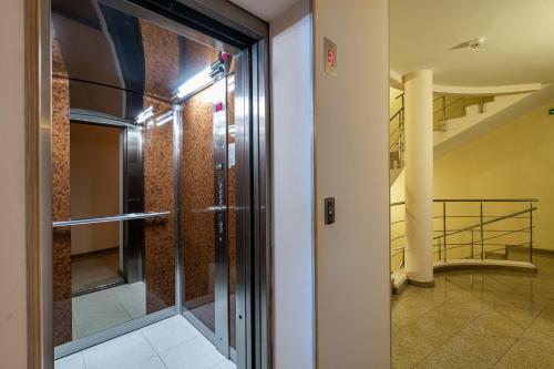 a glass door leading into a hallway with a staircase at Adamo Hotel in Varna City