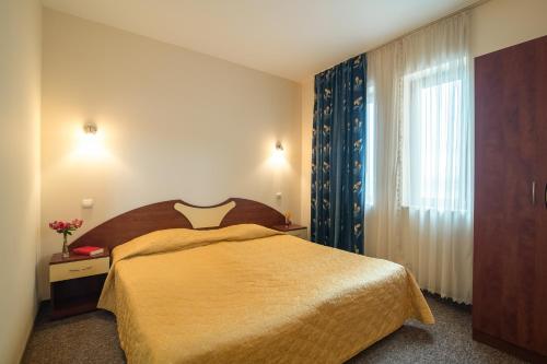 a bedroom with a large bed and a window at Adamo Hotel in Varna City