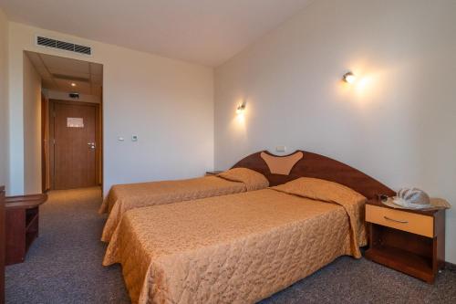 a hotel room with two beds and a telephone at Adamo Hotel in Varna City
