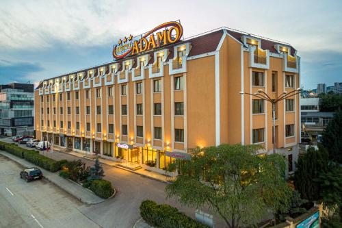 a large building with a sign on top of it at Adamo Hotel in Varna City