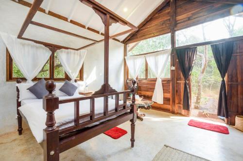 a bedroom with a bed in a room with windows at Namaste Jungle - A Boutique Homestay in Assagao