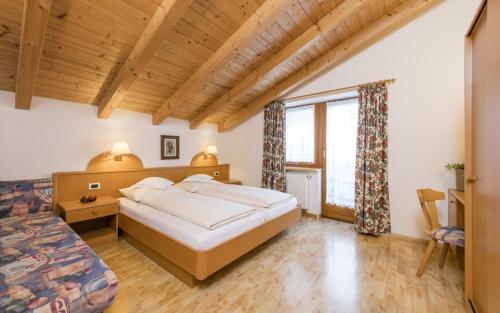 a bedroom with a large bed and a large window at Runcac in Badia